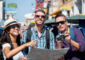 Turistas con mapa en mano explorando una ciudad.